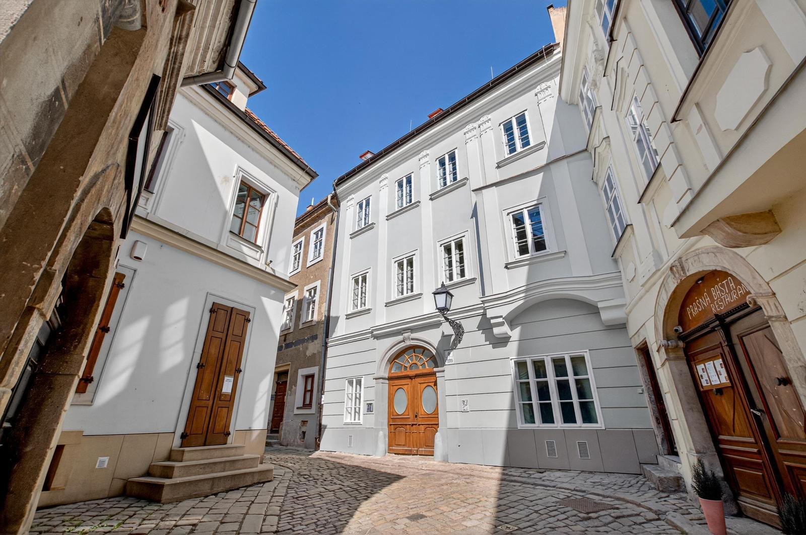 The restored Baroque facade of Zámočnícka 9 on a cobblestone street in Bratislava's Old Town
